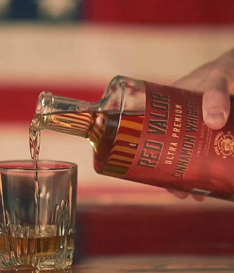 Lifestyle shot of whiskey being poured into a glass tumbler.