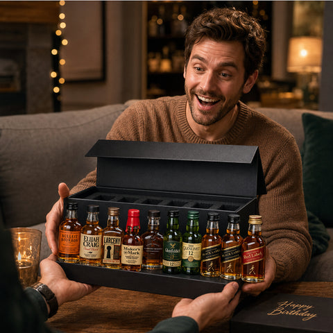 Whiskey Sampler Set 10 gift box being presented at a cozy celebration, featuring Buffalo Trace, Maker's Mark, Woodford Reserve, Elijah Craig Small Batch, Larceny, Bulleit Bourbon, Glenfiddich 12, The Glenlivet 12, Johnnie Walker Black Label, and Johnnie Walker Red Label